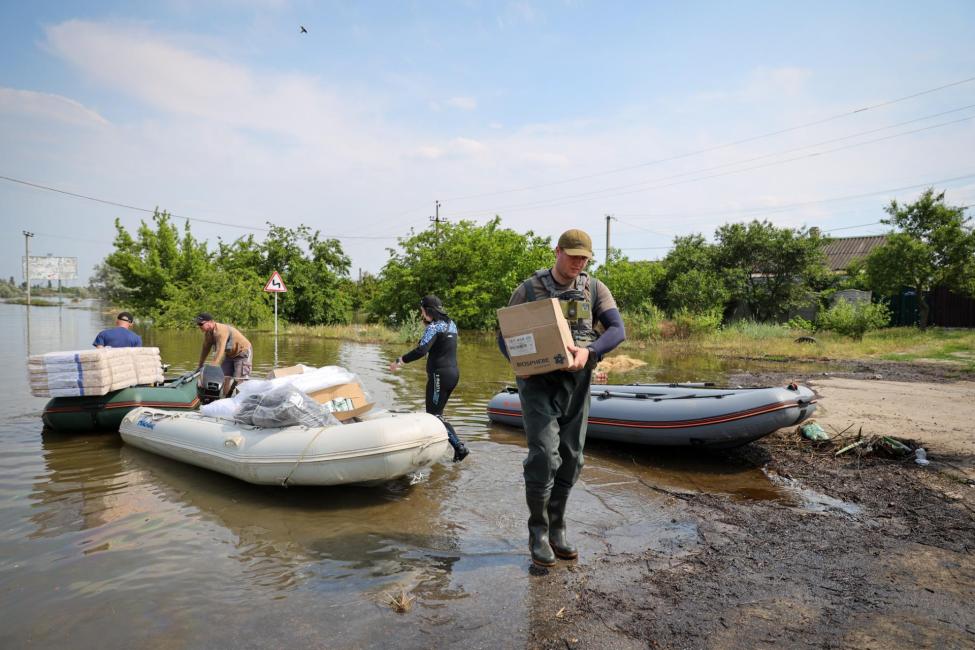 IOM partners bringing aid items to rural areas in Kherson by boat. Photo: Rescue Now 2023
