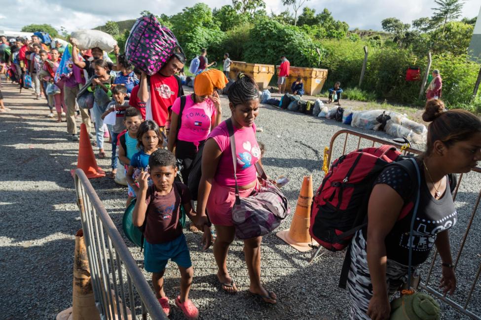 Refugees and migrants from Venezuela enter one of the shelters the Brazilian government has installed in Pacaraima, with the support of international organizations, to offer them protection. Photo: R4V/Valmik Mota. 
 