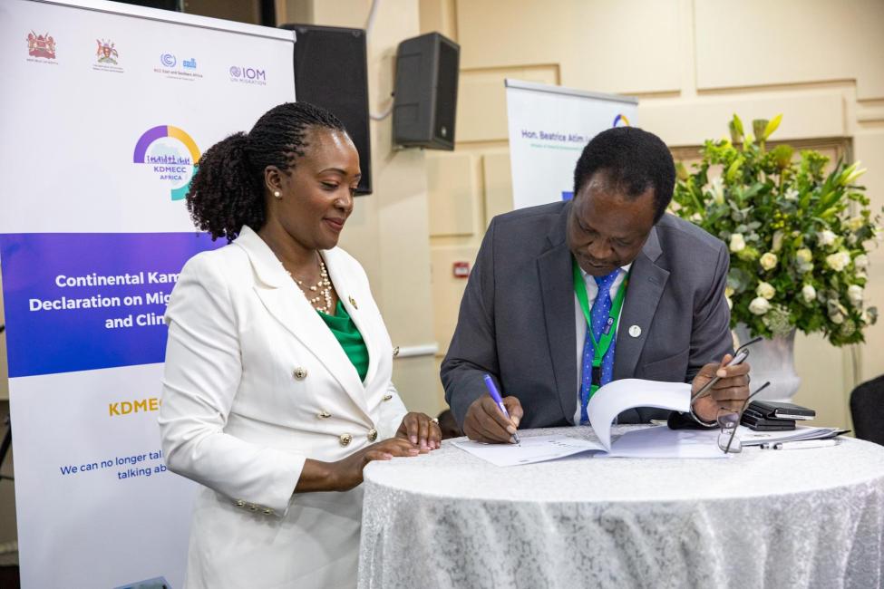 Soipan Tuya, Kenya’s Cabinet Secretary for Environment, Climate Change and Forestry and Sam Cheptoris, Uganda’s Cabinet Minister for Water and Environment, sign the continentally expanded ‘Kampala Ministerial Declaration on Migration Environment and Climate Change at the Africa Climate Summit in Nairobi. Photo: IOM/Kennedy Njagi, 2023.  