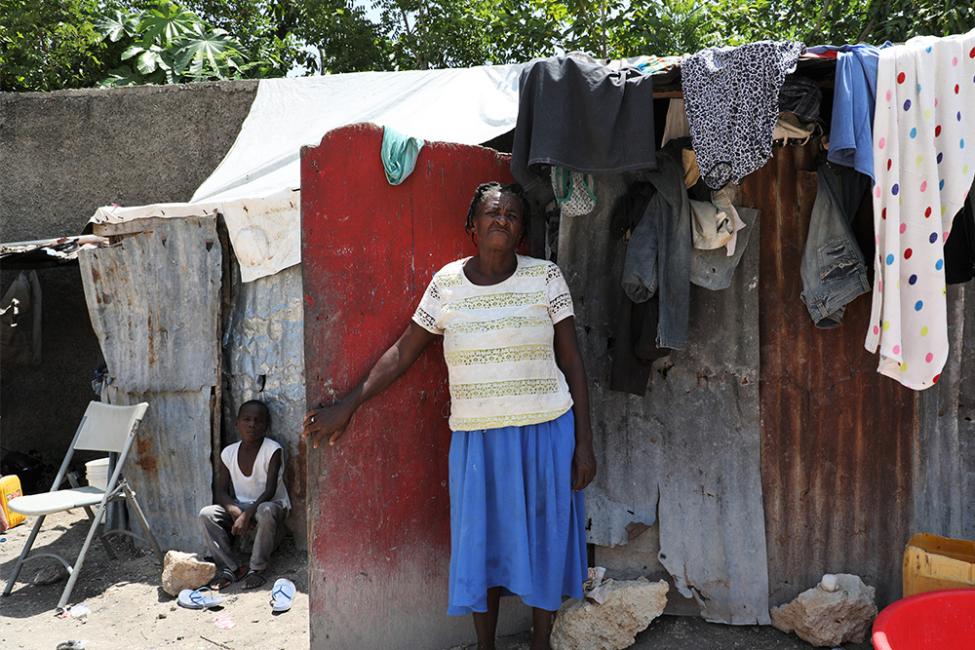 A woman stands in front of her home at a displacement site in Port-au-Prince, Haiti. Photo: IOM