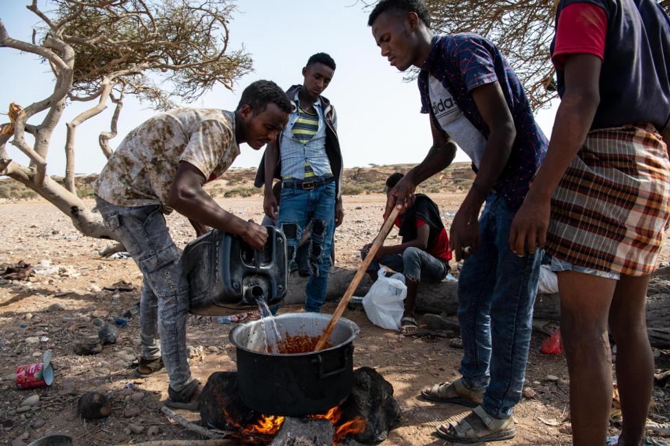 Migrants cook rice in Obock, Djibouti, as they wait for nightfall to continue their journey to Yemen. From there, they hope to reach Saudi Arabia and other Gulf countries. Photo: Alexander Bee/IOM  