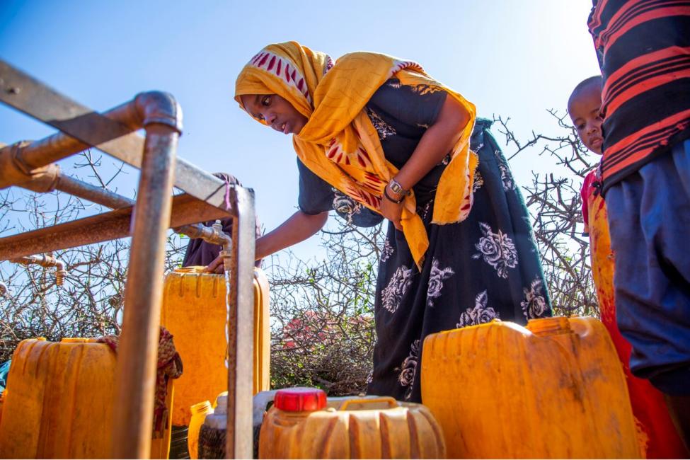 A displaced woman collects water from a borehole constructed by IOM in Baidoa, Somalia. IOM works with Somali communities to promote peace and mitigate the drivers of displacement. Photo: Foresight/ IOM 2020 