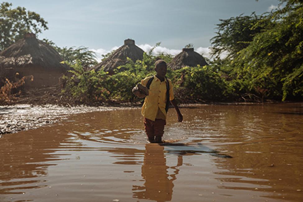 <p>A young boy wades through river water on his way to school in Southern Ethiopia. Photo: IOM/Muse Mohammed</p>
