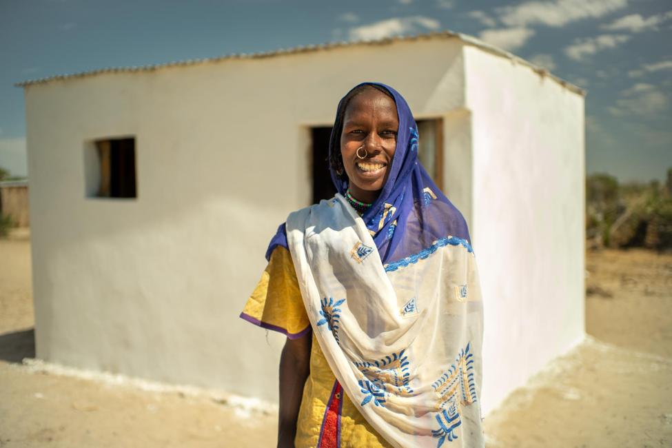 A woman stands in front of her new shelter constructed in the Tagal displacement site. IOM Chad/2020