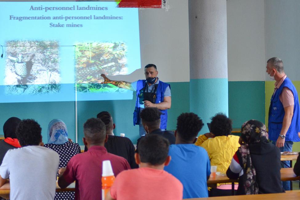 IOM trainers informing migrants and staff on how to spot land mines.