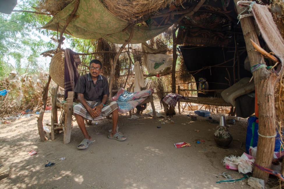 A displaced father sits in the shade of his open shelter in Mokha on Yemen's west coast where tens of thousands have fled to safety from conflict in recent years. Photo: Rami Ibrahim/IOM 2021